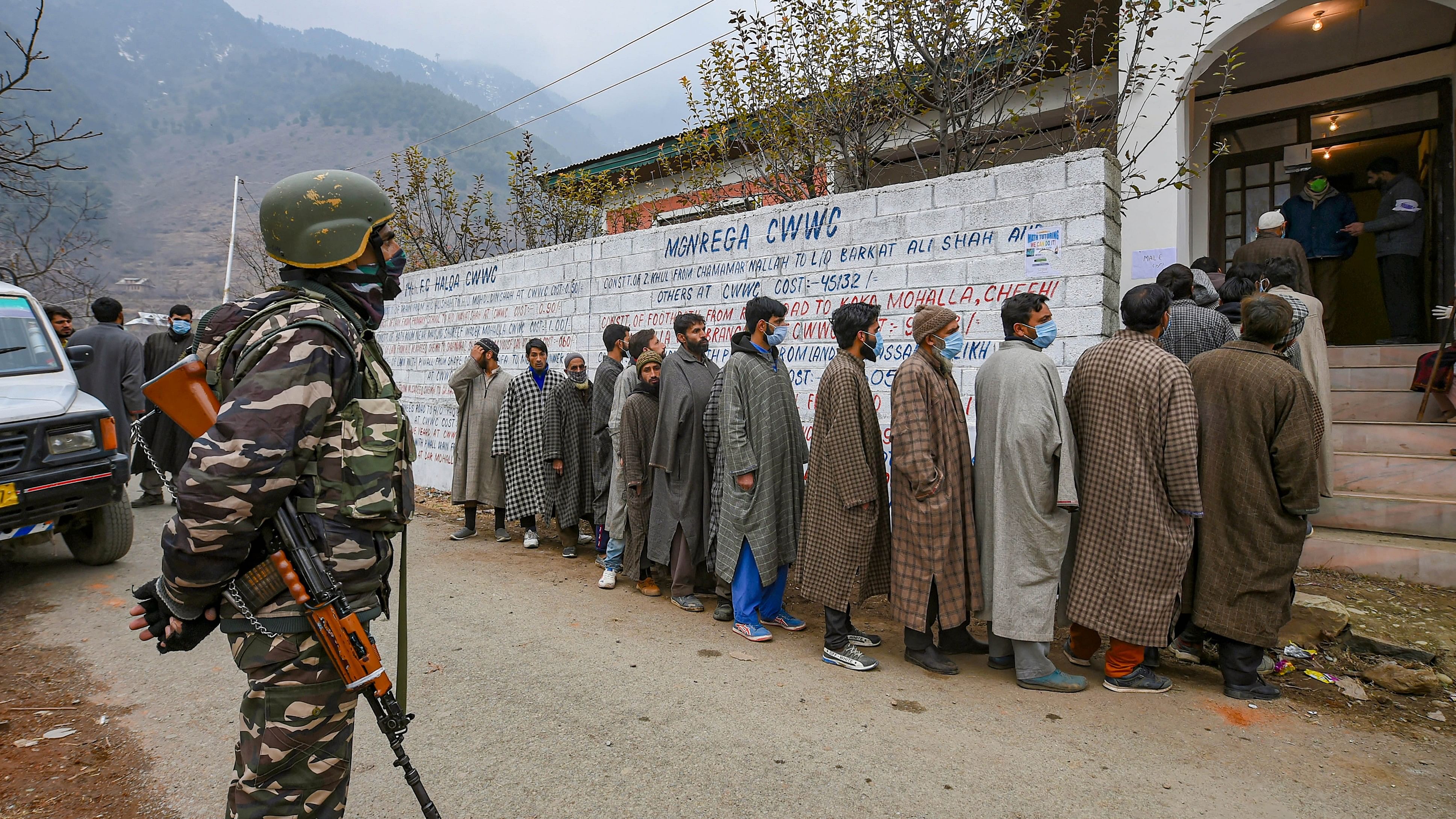 <div class="paragraphs"><p>Residents, wearing 'pherans', wait in a queue to cast their votes on a cold winter morning DDC elections, at Laar in Ganderbal district.</p></div>